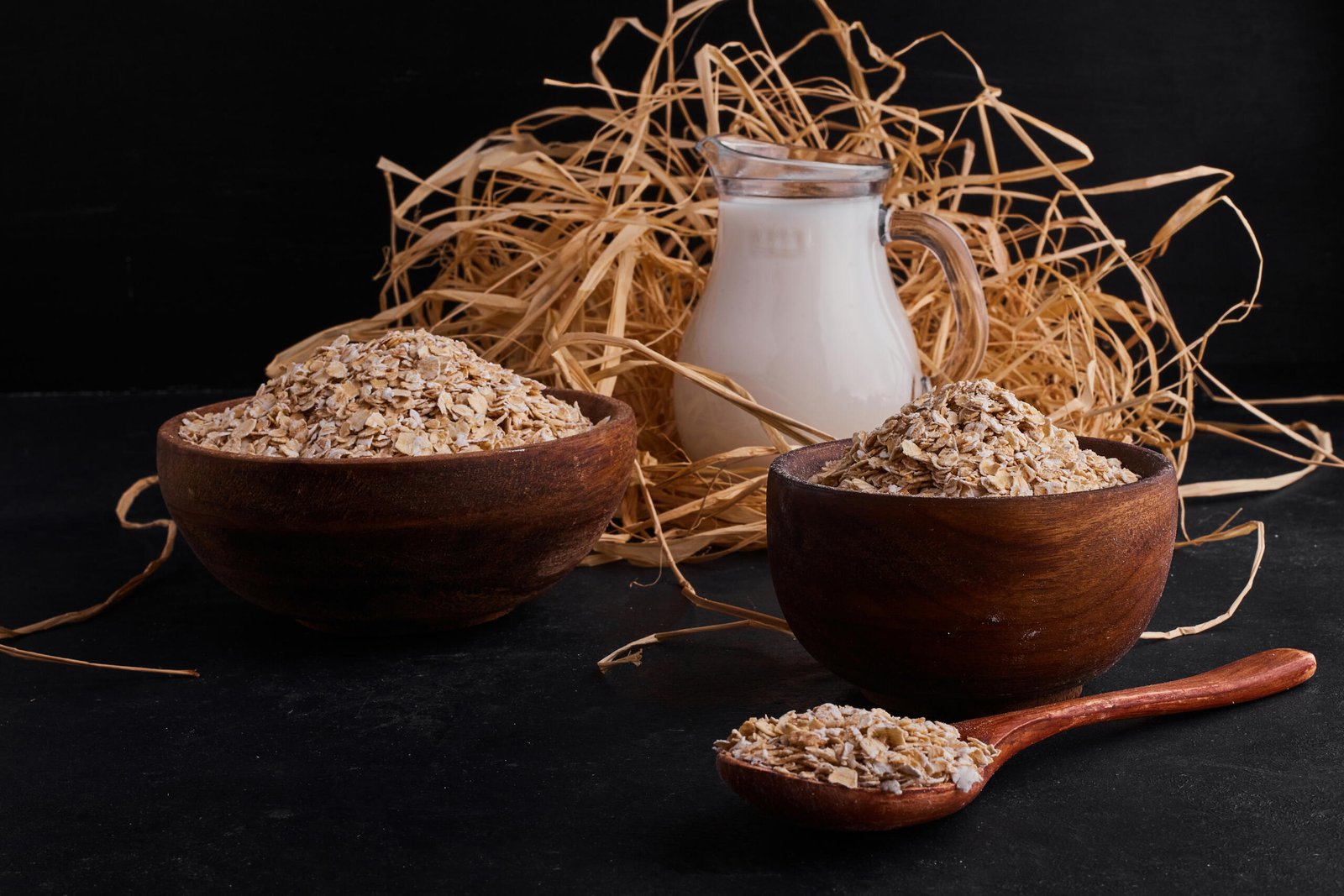 organic mueslies in wooden cups and spoon with a jar of milk